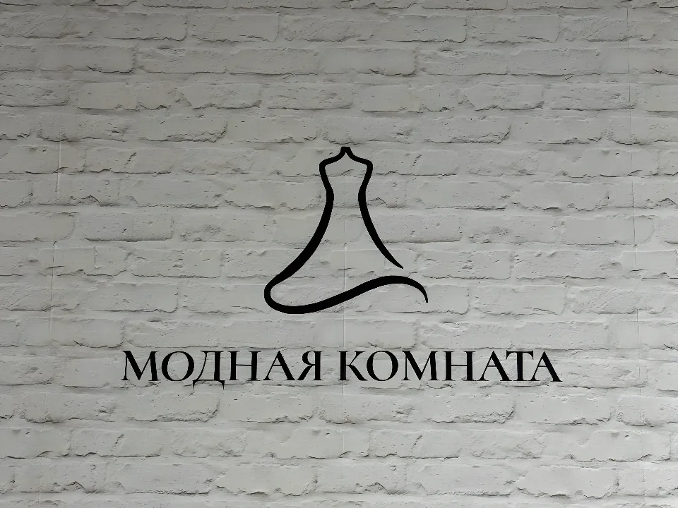 Логотип «Модная комната» на белой кирпичной стене